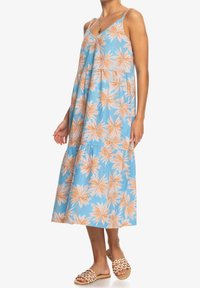 Robe d'été bleue avec imprimé de feuilles de palmier orange, encolure en V et bretelles spaghetti, présentant un design à volants et une silhouette fluide.