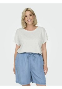 Ljust färgad kortärmad topp med avslappnad passform och subtil prickmönster, i kombination med löst sittande denimshorts med elastisk midja.