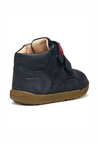 Granatowe zamszowe buty typu high-top z tanowym gumowym spodem, z zapięciem na rzep i czerwonym akcentem. Posiadają teksturowaną skórzaną cholewkę.