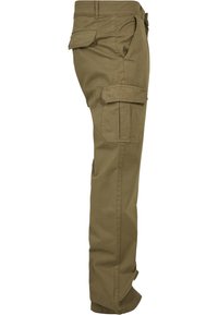 Pantalon cargo kaki vu de profil, avec plusieurs poches à rabat sur la cuisse et près de la hanche.