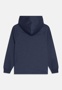 Sudadera con capucha azul marino de textura suave, con mangas raglán y un bolsillo tipo canguro. Presenta una capucha sin costuras y puños elásticos.