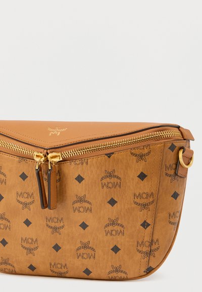 Τσάντα ώμου από δέρμα ταμπά με ανάγλυφο λογότυπο MCM, χρυστό φερμουάρ, μοτίβο διαμαντιού και καμπυλωτό σχήμα. Διαθέτει επάνω κλείσιμο με φερμουάρ και αποσπώμενο ιμάντα.