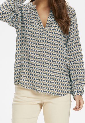 Langärmlige Bluse in Creme mit einem geometrischen Muster aus blauen und olivgrünen Rauten, mit einem V-Ausschnitt und gerafften Bündchen.