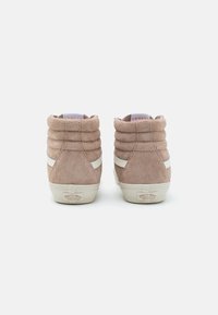 Høye sneakers i lys taupe sveitsisk semsket skinn med vertikal ribbing, hvit sidestripe og beige gummisåle. Logo synlig på hælen.