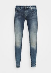 Jeans de denim azul ajustados, con detalles de lavado desgastado, cierre frontal de botón y diseño estándar de cinco bolsillos.
