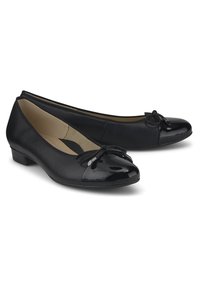 Ballerines noires en cuir lisse avec un bout en vernis brillant, ornées d'un petit nœud et d'un petit talon.