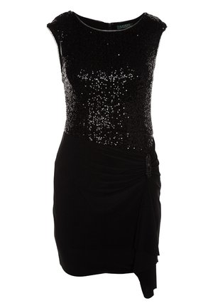 Robe noire avec un corsage orné de sequins, une silhouette ajustée et un détail de volant sur le côté. Complétée par des collants noirs transparents et des escarpins à bout pointu.