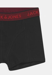 Black boxer shorts made of soft fabric, featuring a red knitted waistband with "JACK & JONES" logo in repeating pattern and stitched seams.