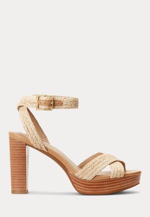 Beige flettet ankelrem sandal med gylden spænde, træ blok hæl og plateau sål.