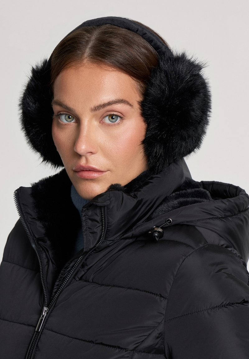 Giacca a vento nera con cappuccio e cuffie foderate di pelliccia. La giacca presenta una zip e texture trapuntata. Le cuffie sono morbide e di forma circolare.