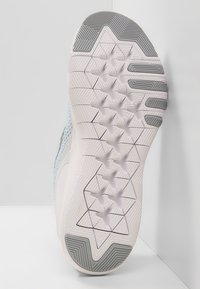 Podeszwa buta z teksturowanej gumy, z geometrycznymi wzorami w odcieniach szaro-białych, z górną częścią z jasnoniebieskiej siateczki.