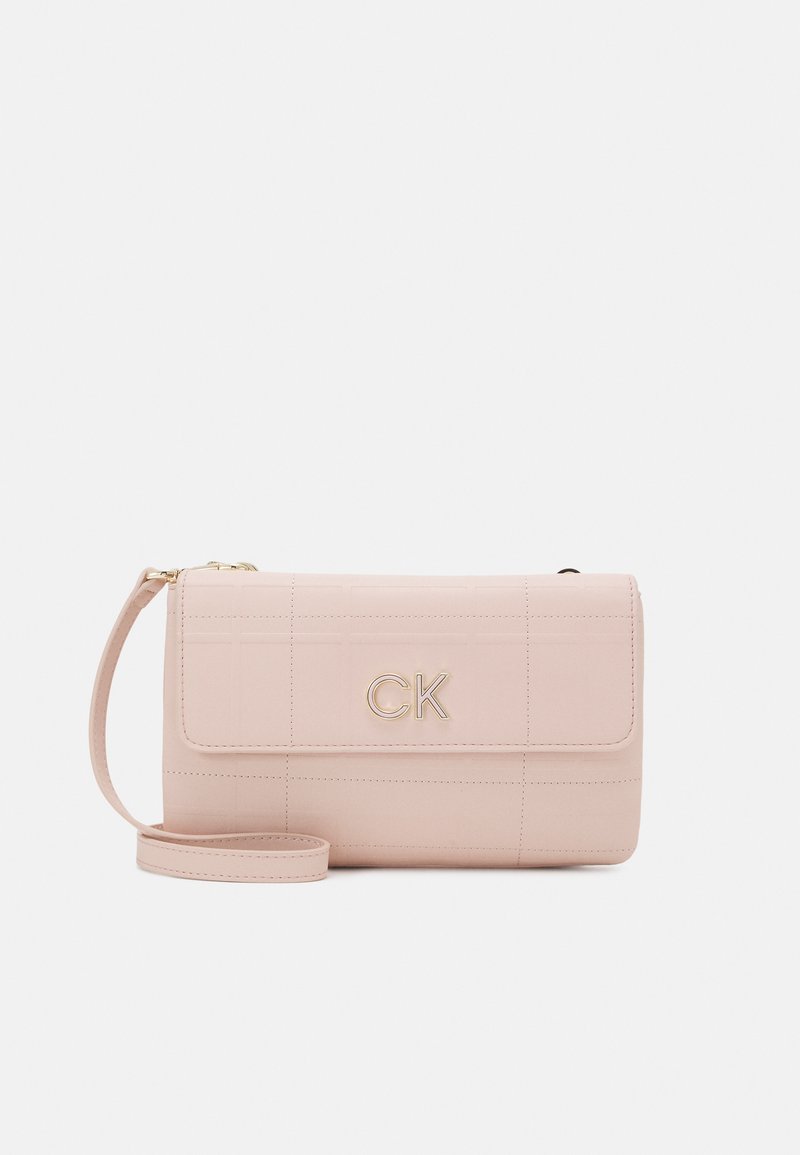 Mjuk rosa faux läderhandväska med rektangulär form, kviltad textur och gyllene detaljer med en monogramlogotyp. Justerbar rem ingår.