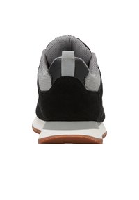 Czarno-szare sneakersy z siateczkowej tkaniny i zamszowymi detalami, wyściełanym kołnierzem, pętlą na pięcie oraz białą podeszwą środkową i brązową podeszwą zewnętrzną.