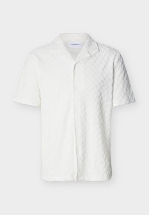 Fehér, rövid ujjú, gombos ing texturált sakktábla mintával és bevágott gallérral, egyszínű háttéren kiállítva.