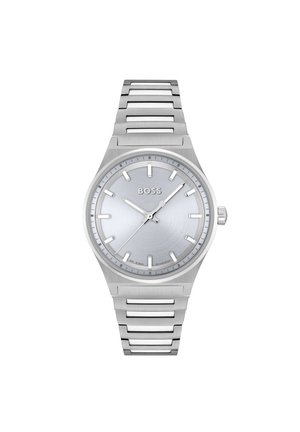 Montre en acier inoxydable argenté avec un cadran brossé, des indicateurs d'heure minimalistes et un bracelet à maillons. Présente des aiguilles audacieuses et le logo de la marque.