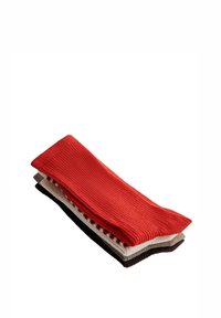 Pile de cinq chaussettes côtelées en rouge, blanc, gris, noir et marron, pliées et posées sur un fond blanc.