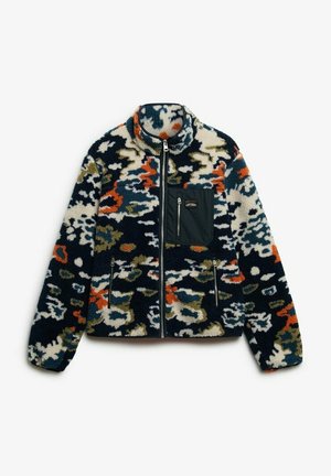Fuzzy jacket with a high collar, featuring an abstract multi-color pattern of navy, white, green, and orange, with a zippered chest pocket.