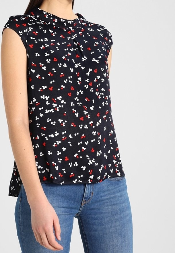 Blusa a stampa floreale in nero, con fiori rossi e bianchi, maniche corte e vestibilità comoda. Tessuto morbido, dettaglio plissettato sul davanti, stile casual.