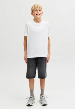 Witte T-shirt met korte mouwen en een textuurlogo, gecombineerd met donkergrijze denimshorts en lichtgrijze sneakers. Casual look, neutrale kleuren.
