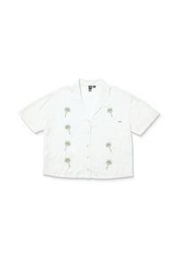 Chemise à manches courtes, à boutons, en tissu blanc avec broderie de palmier verte. Dispose d'une poche plaquée sur le côté gauche.