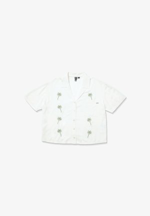 Chemise à manches courtes, à boutons, en tissu blanc avec broderie de palmier verte. Dispose d'une poche plaquée sur le côté gauche.