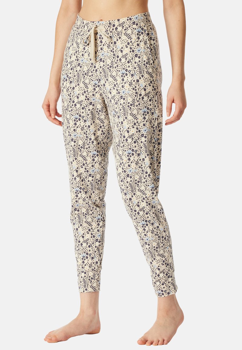 Pantalons à motifs floraux en beige clair avec des dessins bleus et bleu marine foncé. Tissu doux avec taille à lacet. Ajustés aux chevilles.