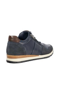 Navy blue sneaker with leather and suede materials. Features a brown accent heel, textured side panels, and a contrasting white sole.