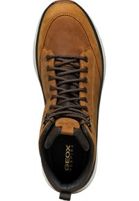 Zapato de senderismo de cuero marrón con un cuello de tela texturizada, cordones marrones y una suela de goma ligera. Presenta una plantilla con la marca visible en el interior.