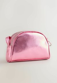 Metaliczna różowa kosmetyczka w zaokrąglonym kształcie, gładka w dotyku, z błyszczącym suwakiem i boczną rączką dla łatwego przenoszenia.