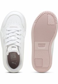 Baskets blanches avec une tige en cuir lisse, des lacets plats et un bout perforé. La semelle extérieure en caoutchouc rose présente une adhérence texturée et un logo.