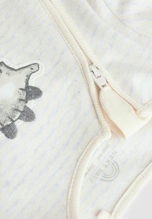 Body en coton avec des rayures jaunes claires et blanches, orné d'une application de tortue grise et d'une fermeture éclair blanche sur le côté. Texture douce.