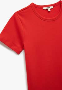 Rode t-shirt met korte mouwen, gemaakt van zacht katoen. Voorzien van een ronde halslijn en schone naden. Stevige textuur zonder zichtbare patronen of graphics.