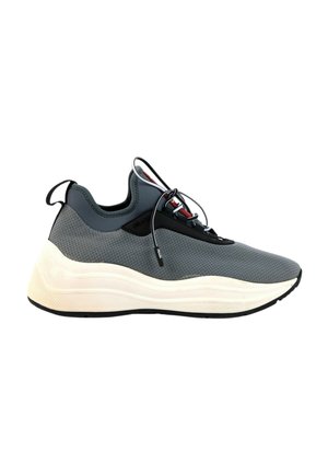 Nowoczesny szary sportowy sneaker z siateczkową cholewką, czarnymi sznurówkami, pętelką na pięcie oraz grubą białą, teksturowaną podeszwą.
