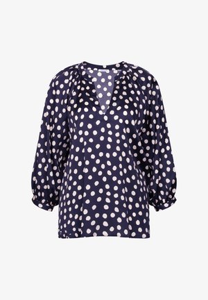 Blouse bleu marine à pois blancs irréguliers, encolure ronde avec découpe en V, et manches trois-quarts bouffantes avec poignets élastiques.