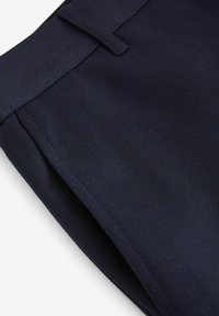 Pantaloni bleumarin cu o textură netedă, având un front plat și cusături subtile. Talie include un pas pentru curea pentru un detaliu suplimentar.