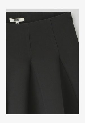 Jupe noire avec un design structuré, des plis et une texture lisse. Comprend une fermeture éclair cachée et une taille étiquetée.