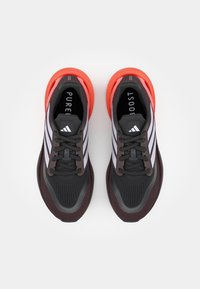 Zwarte en rode sport schoenen met een bovenwerk van mesh, voorzien van drie witte strepen, ronde veters en een gestructureerde zool voor grip.