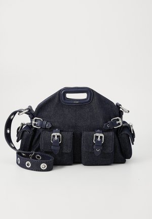 Dunkelblaue Denim-Tasche mit runder Form, mehreren äußeren Taschen, verstellbarem Tragegurt und silberfarbenen Hardware-Akzenten. Mit Traggriff versehen.