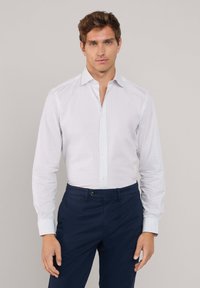 Witte geblokte broekshirt met kraag en lange mouwen, gecombineerd met donkerblauwe broek. Knopf front en slim-fit ontwerp. Gladde textuur.