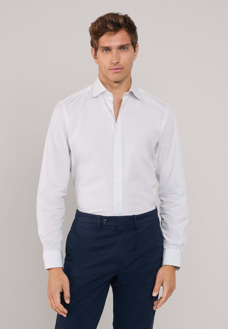 Witte geblokte broekshirt met kraag en lange mouwen, gecombineerd met donkerblauwe broek. Knopf front en slim-fit ontwerp. Gladde textuur.