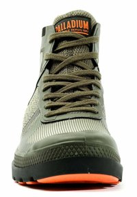 Baskets montantes olive en tissu texturé, côtés à motifs, semelle en caoutchouc noire et accents orange vif. Les lacets sont vert foncé.