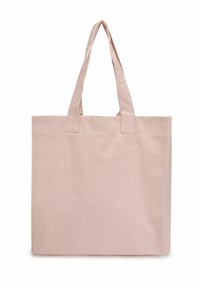 Sac en toile de coton rose clair, doté de deux poignées robustes, d'une forme carrée simple et d'une surface lisse et sans ornement.