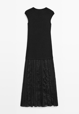 Ärmelloses schwarzes Kleid mit einem taillierten Strickoberteil und einem langen, plissierten, strukturierten Rock, der unterhalb des Knies endet.