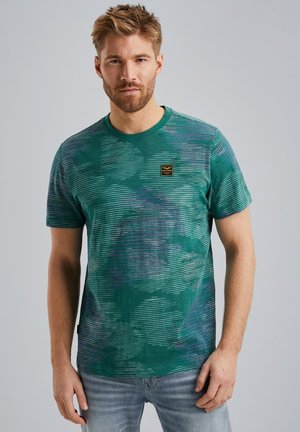 Groene t-shirt met korte mouwen, voorzien van een gestreept en camouflagepatroon, ronde hals en een klein zwart label op de borst. Gemaakt van zachte stof.