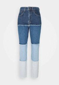 Jeans de cintura alta con un diseño de patchwork de denim azul oscuro y claro. Los dobladillos desflecados añaden textura. Corte recto, estilo de cinco bolsillos.