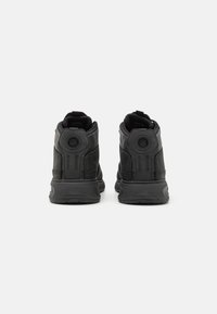 Czarne sneakersy wysokie z gładkiego materiału syntetycznego, zaokrąglony czubek, wyściełany kołnierz oraz teksturowane akcenty na pięcie i bokach.