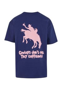 Mörkblå bomullströja med en rosa grafik av en cowboy på en häst med texten "Cowboys tar inte tupplurar. De koffeinar."