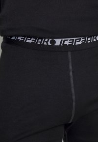 Intimo nero con un elastico testurizzato e un logo stampato a contrasto. Tessuto liscio con un design aderente.