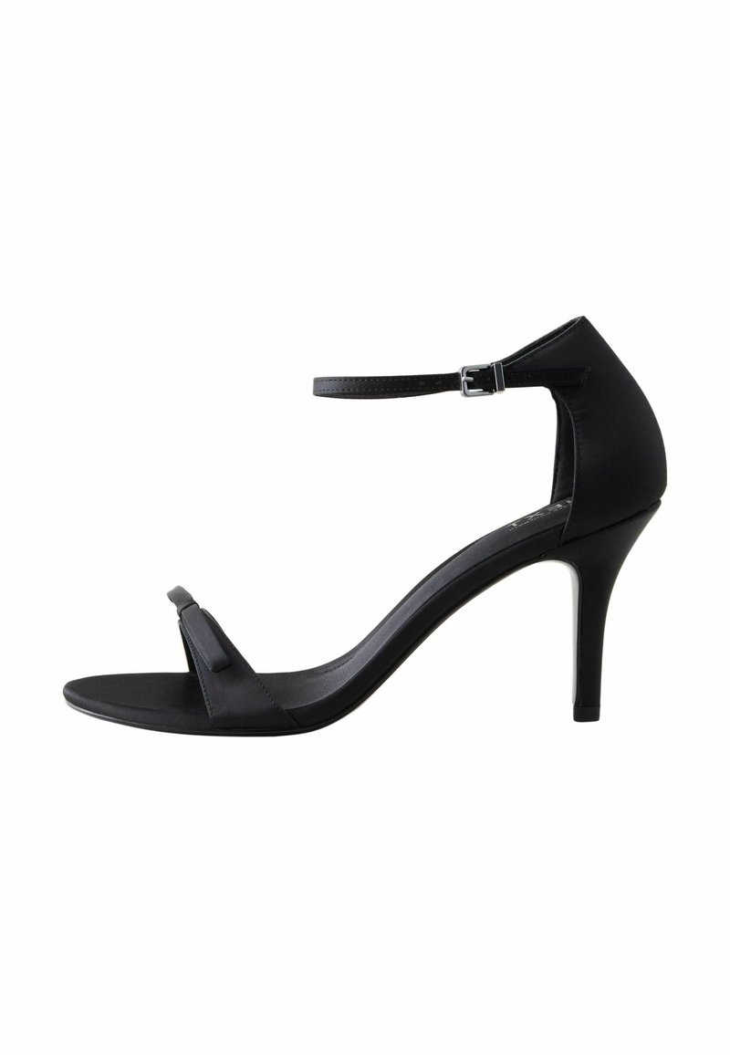 Sorte højhælede sandaler med en glat satinfinish. Har et minimalistisk design, tynd ankelstrop og en dekorativ sløjfe ved tåen.