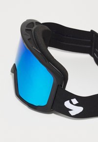 Gafas de esquí negras con un forro de espuma y una correa ajustable negra que presenta un logo blanco. Las lentes son azules con un acabado espejado.